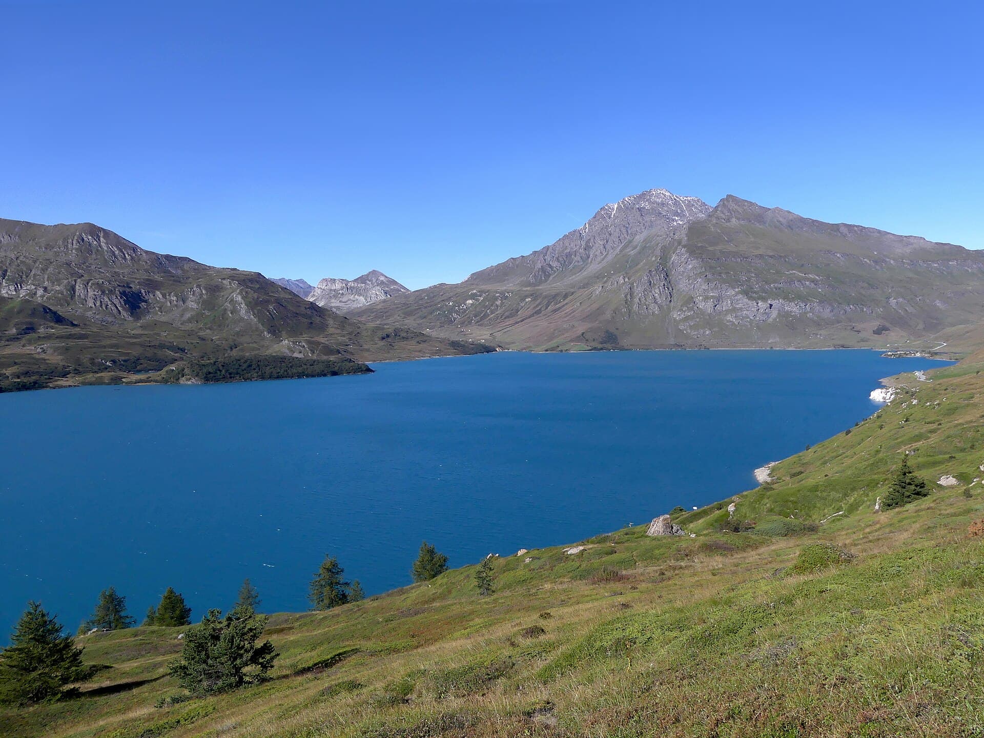 Vaste lac d'altitude aux eaux bleu profond entre les cimes